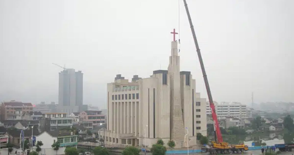 A cross is being removed from atop a large church.