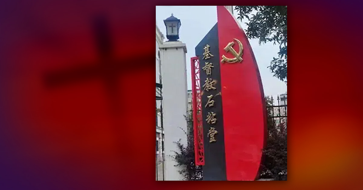 A church sign has a hammer and sickle affixed to the side of it.